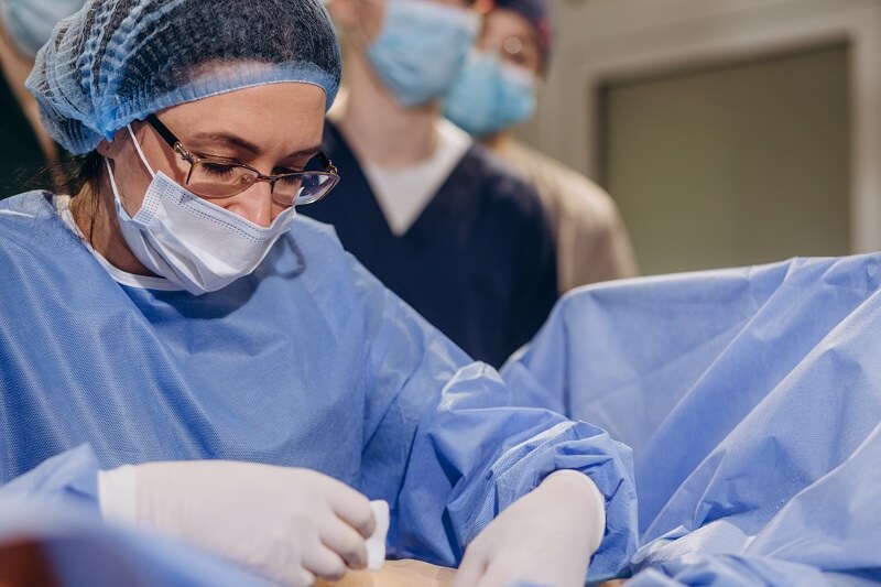 A cirurgia aberta envolve a remoção do aneurisma e a substituição da seção afetada